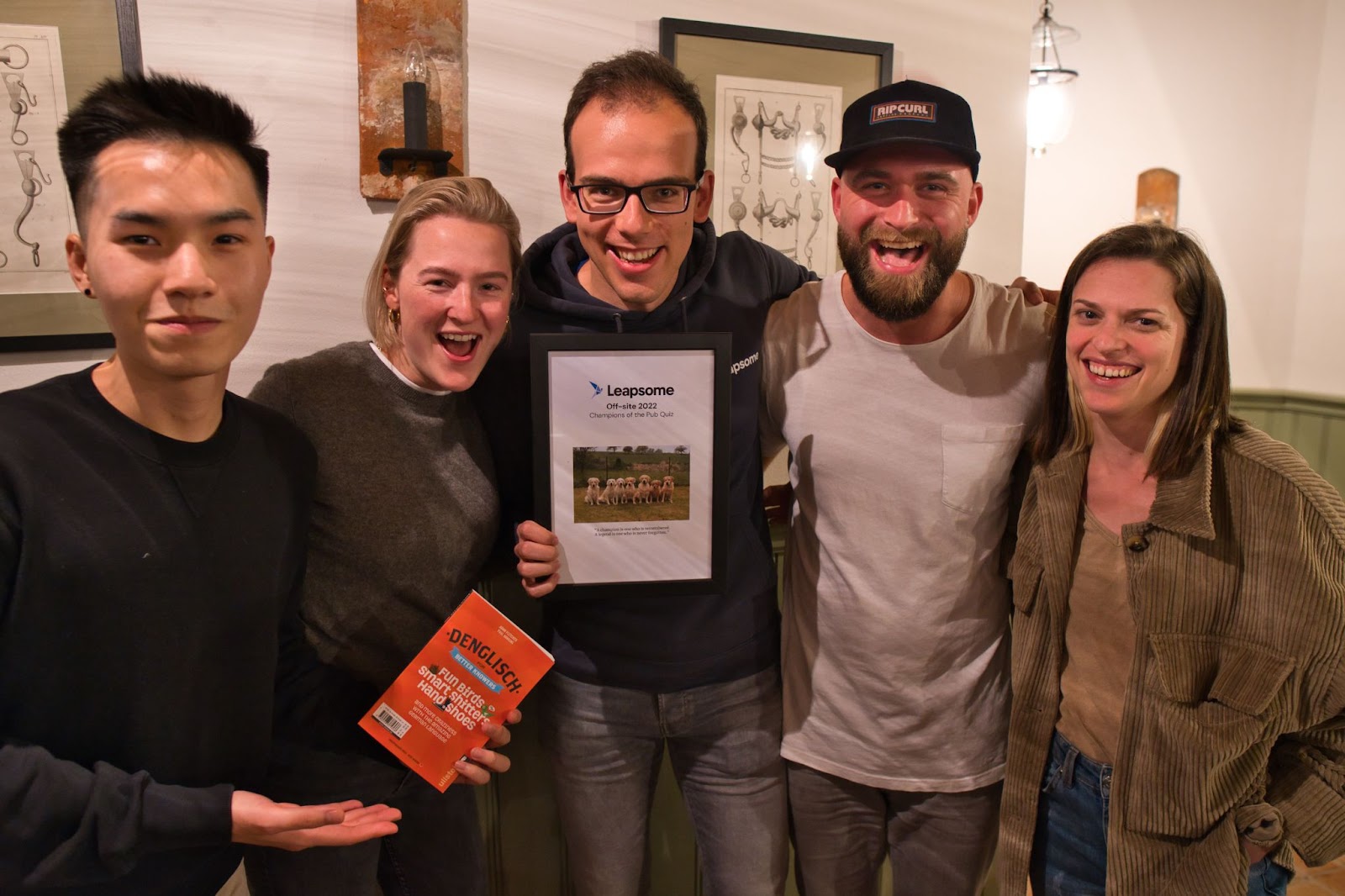 Photo of five Leapsome employees celebrating their victory in the pub quiz played at the offsite