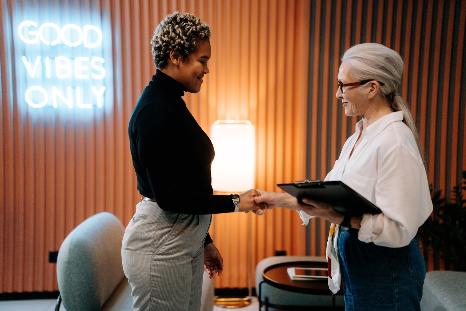 Manager shaking hands with employee after their performance review.