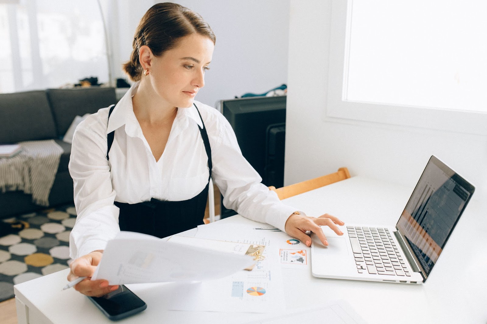 A professional woman looking at a laptop