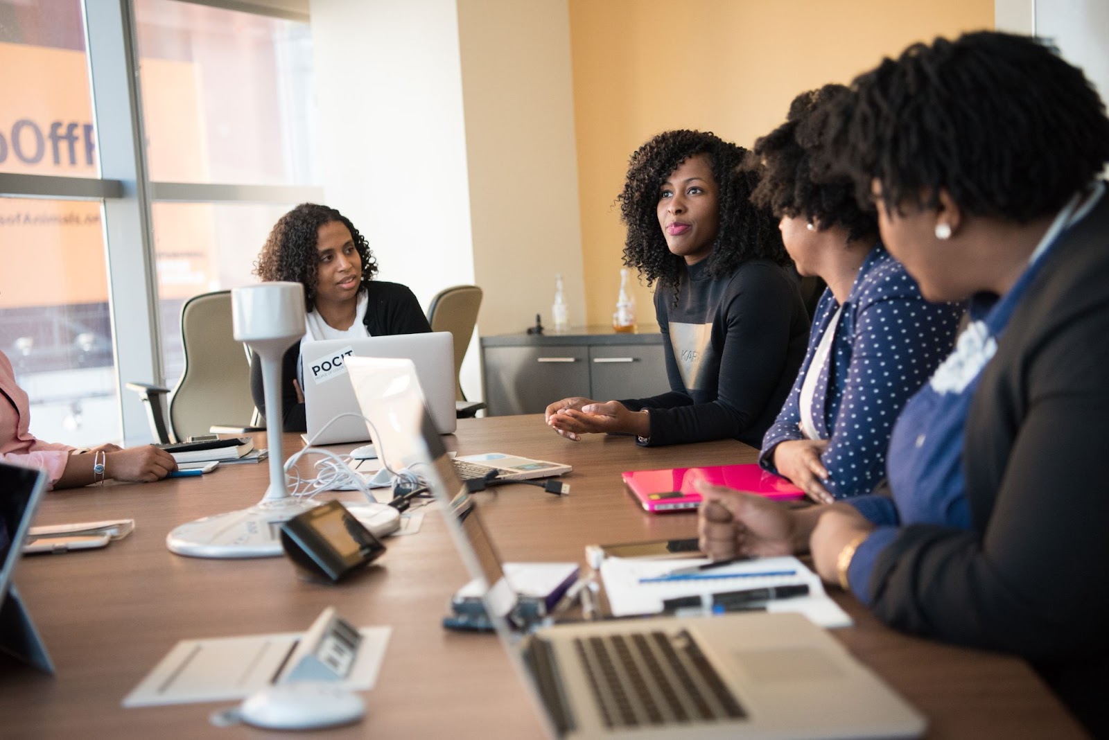 Photo of employees sitting at a table in discussion during a meeting