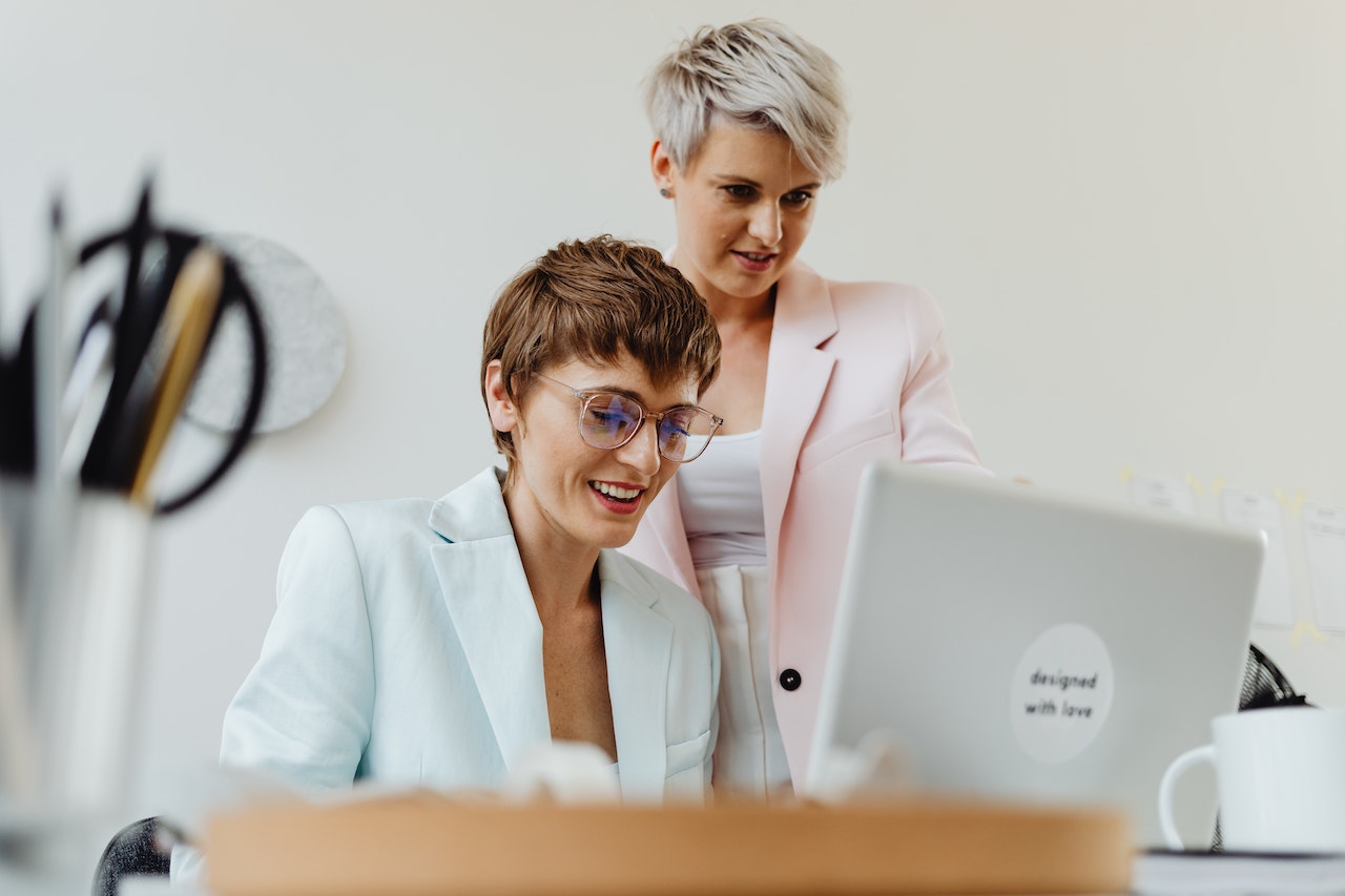 A photo of two professionals looking at a laptop screen.