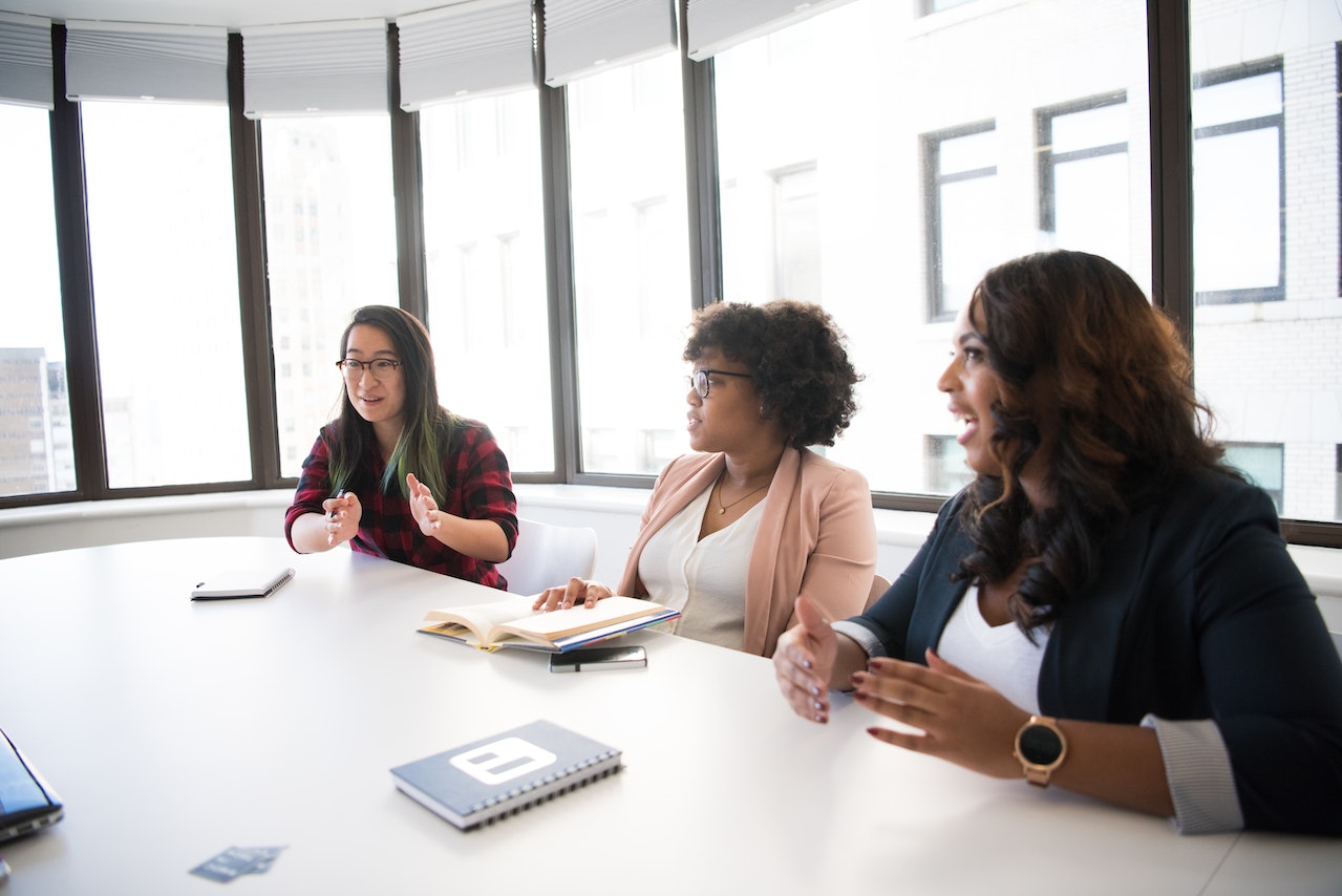 A photo of three employees in a meeting.