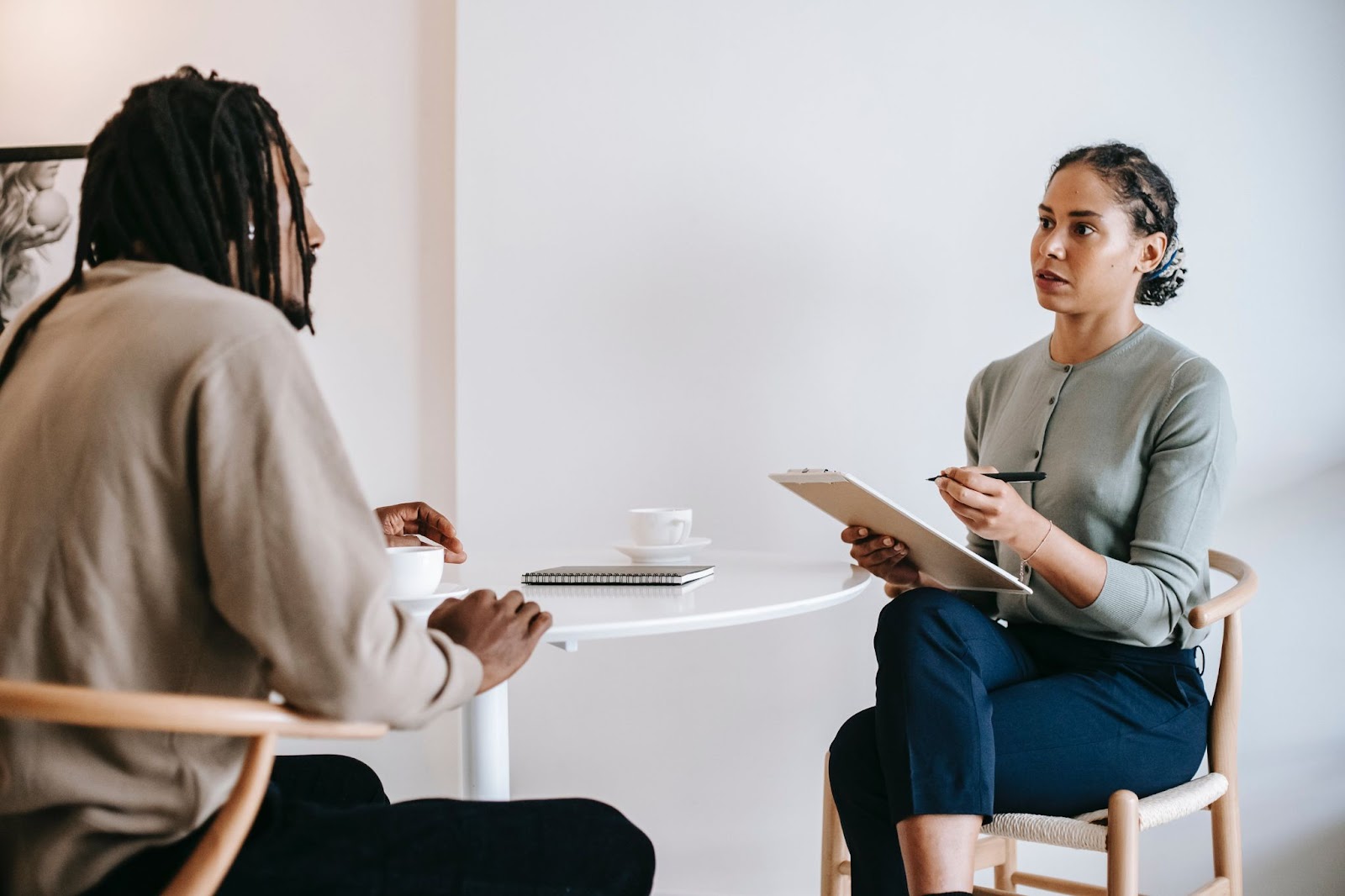 A photo of two professionals having a sit-down 1:1 discussion in a professional environment.