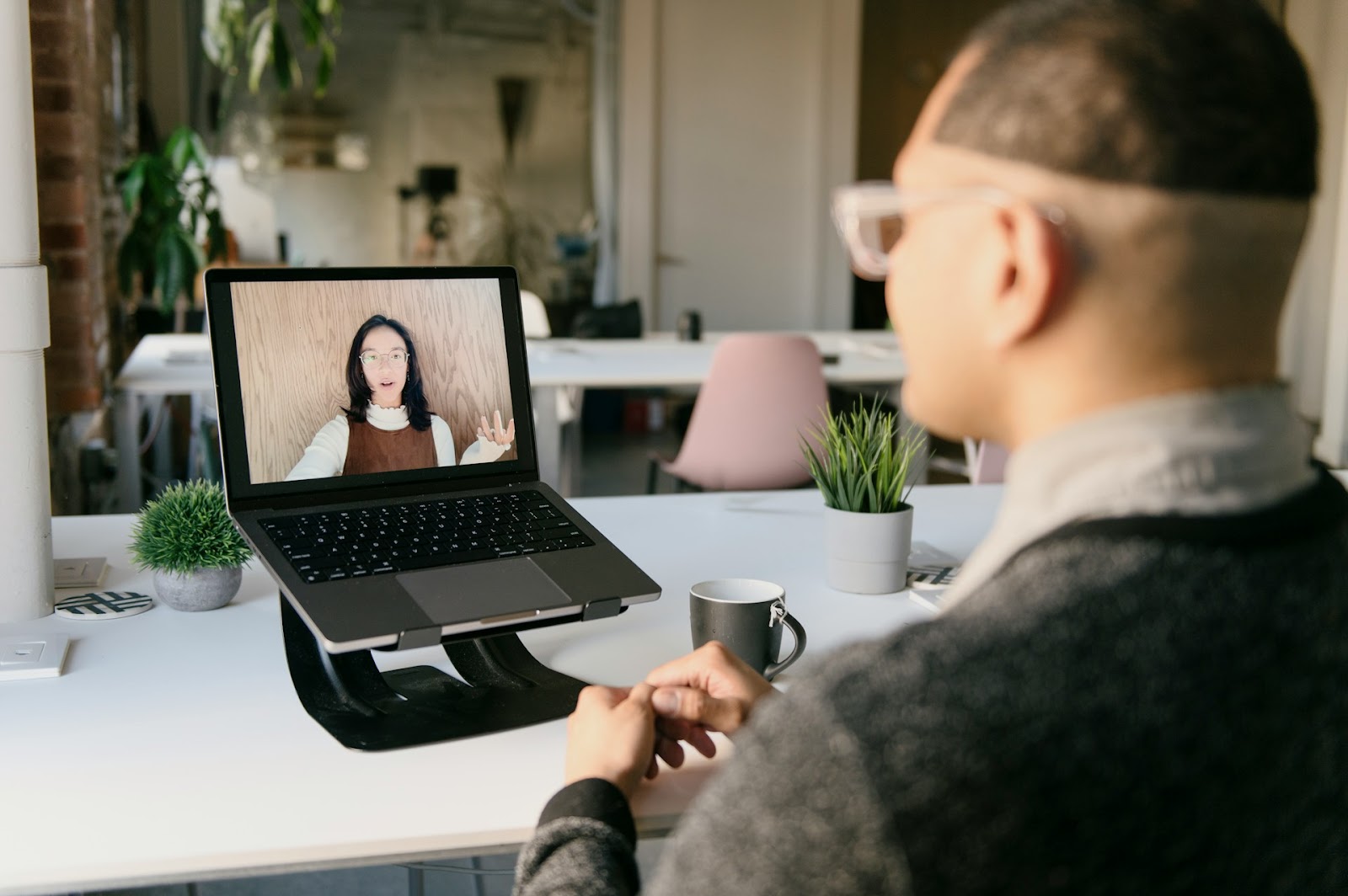 A photo of an employee in a virtual meeting with a manager.