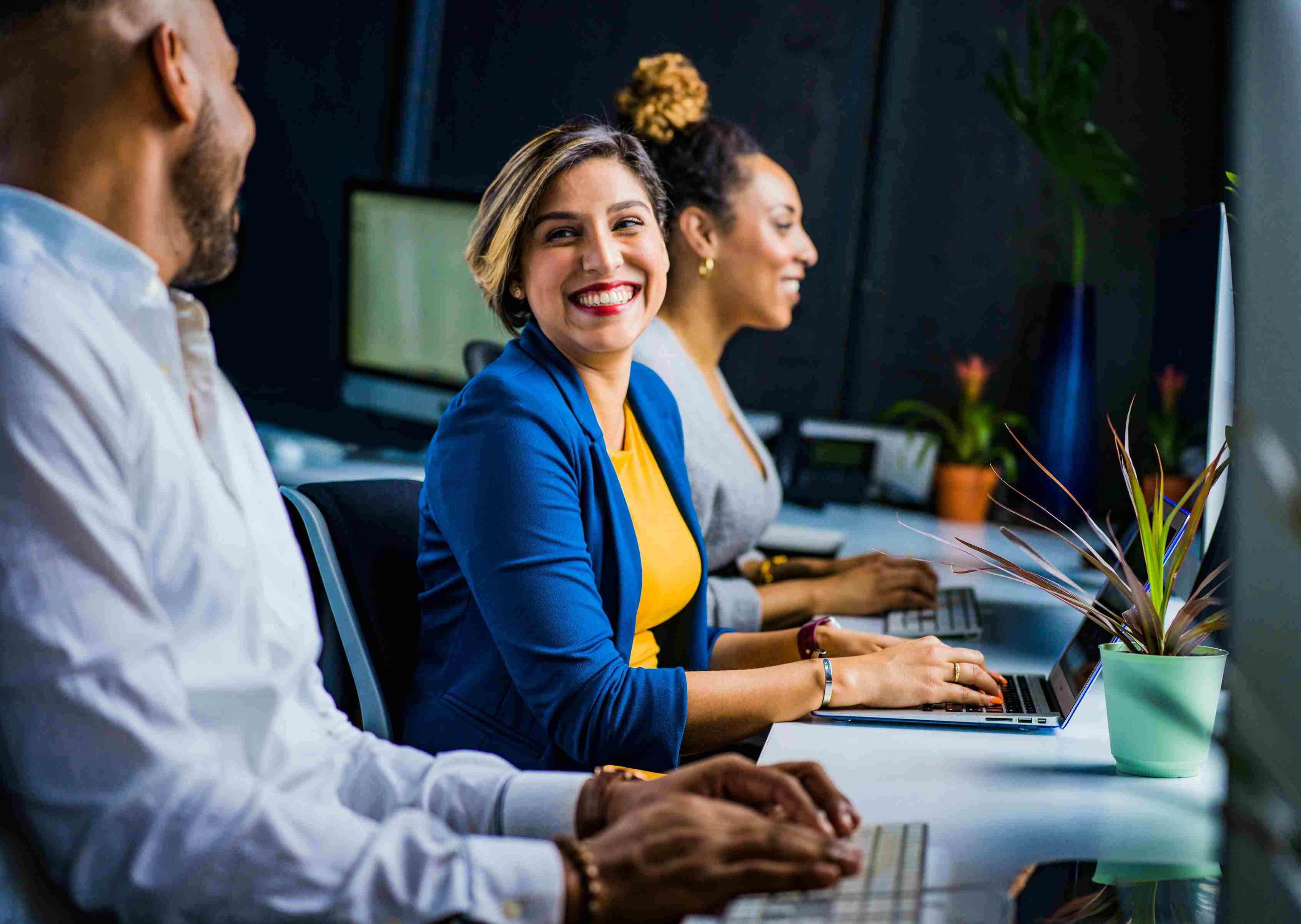 Photo of happy employees communicating with each other and being productive at work