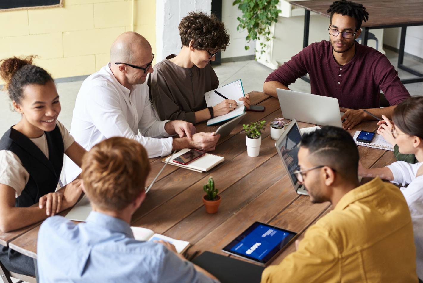 Photo of a group of employees working and talking around a meeting table