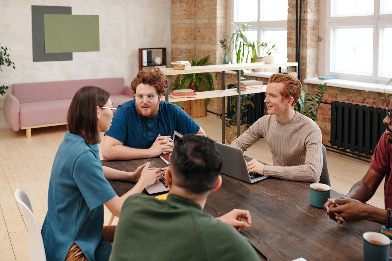 Photo of five employees in a planning meeting.