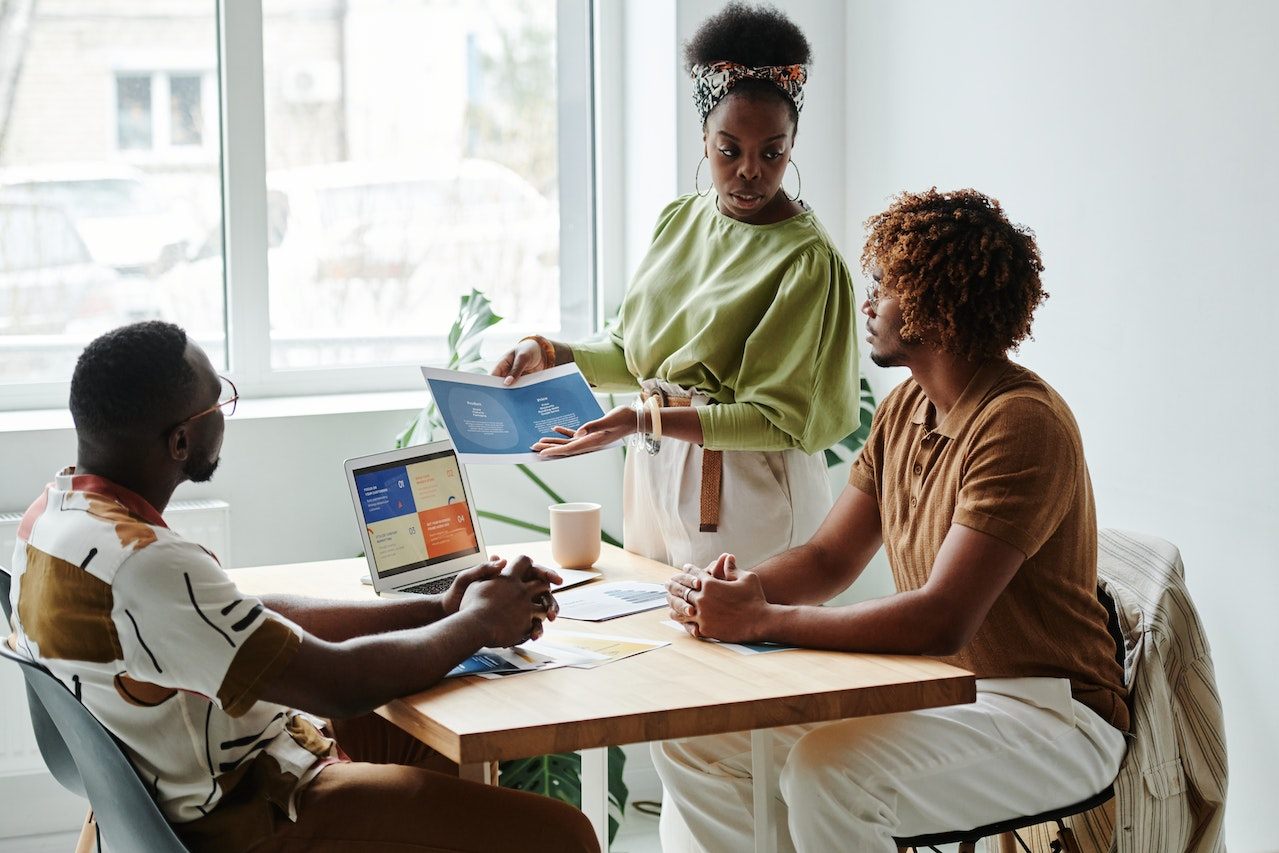 Photo of an employee presenting data to two other employees.