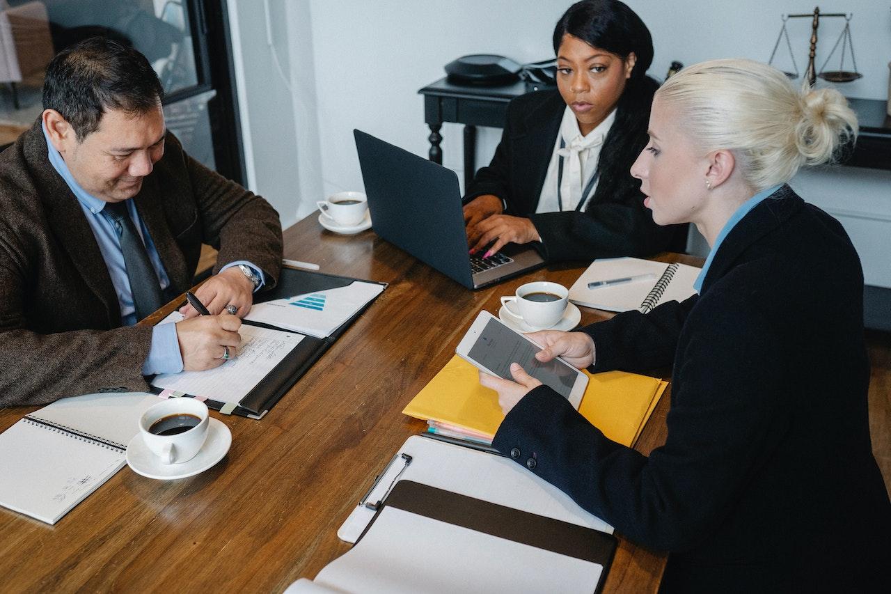 Photo of three employees in a meeting.