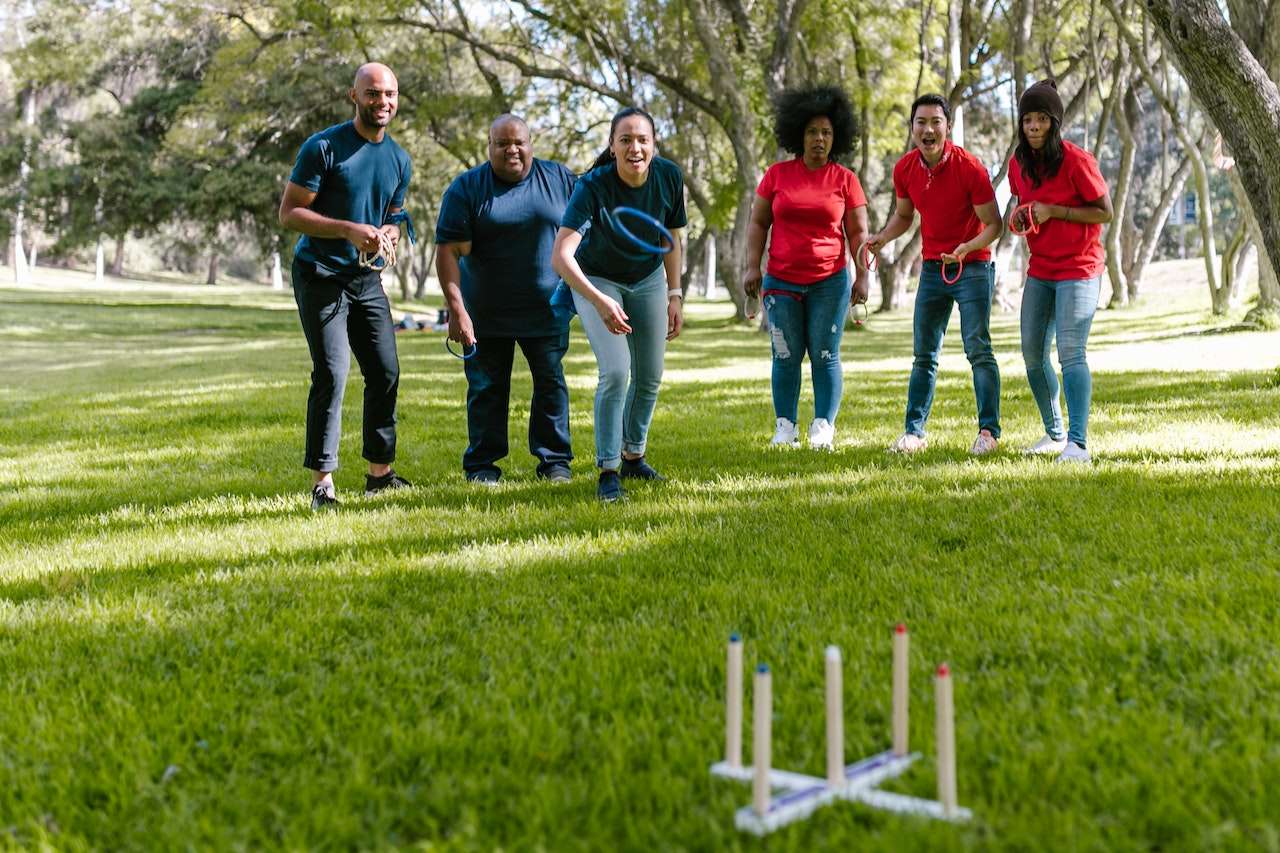 Photo of a group of employees playing an outdoor game in a park.