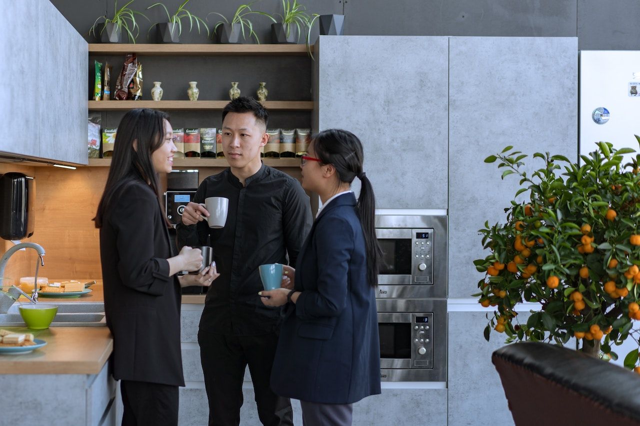 Photo of employees showing a new hire where the staff kitchen is.