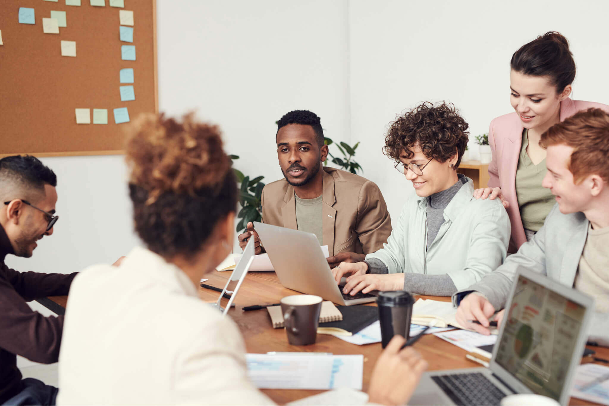 A group of professionals sat around a meeting room table.