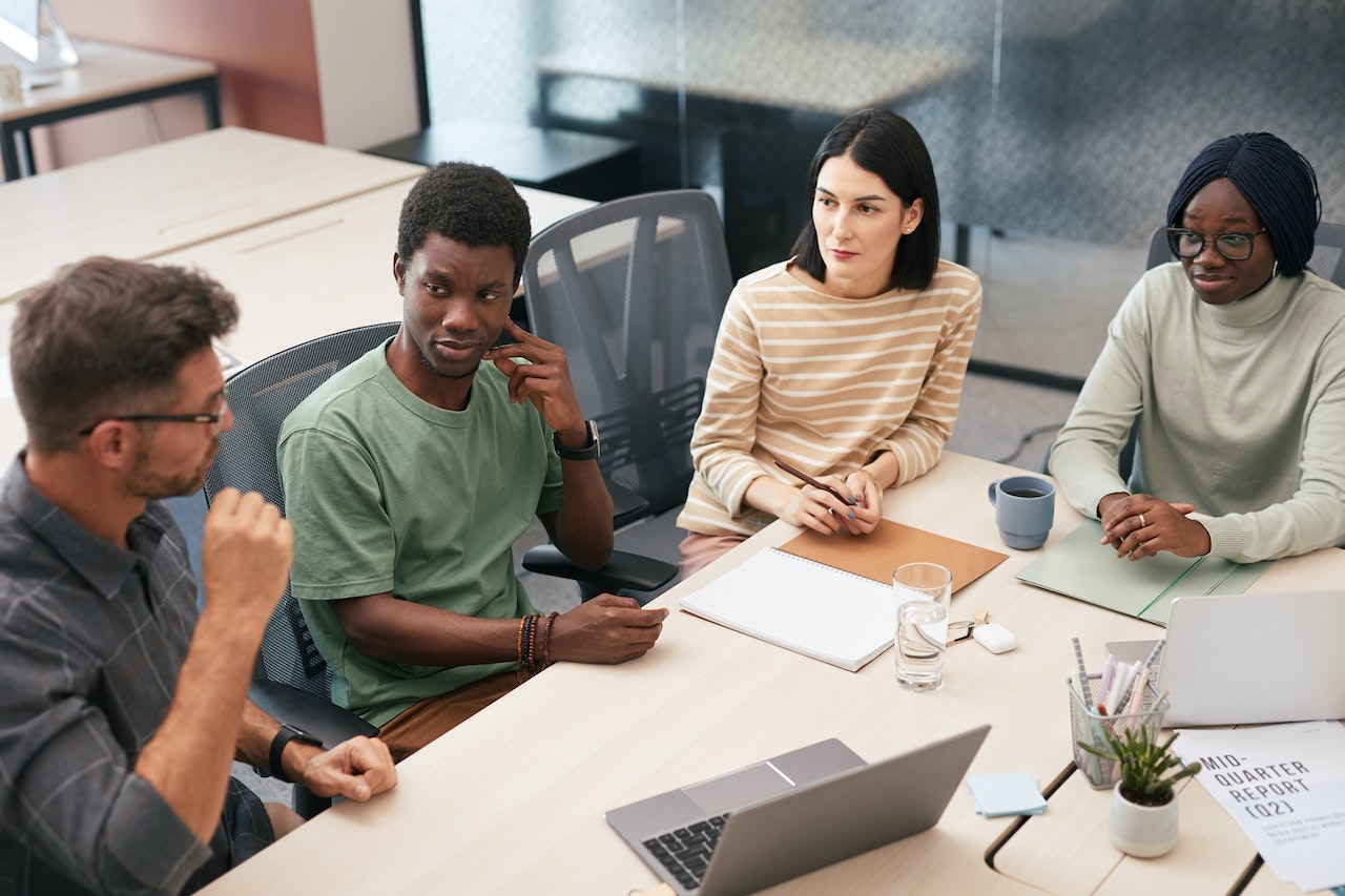 A photo showing a group of employees sitting together at a table planning an initiative. 