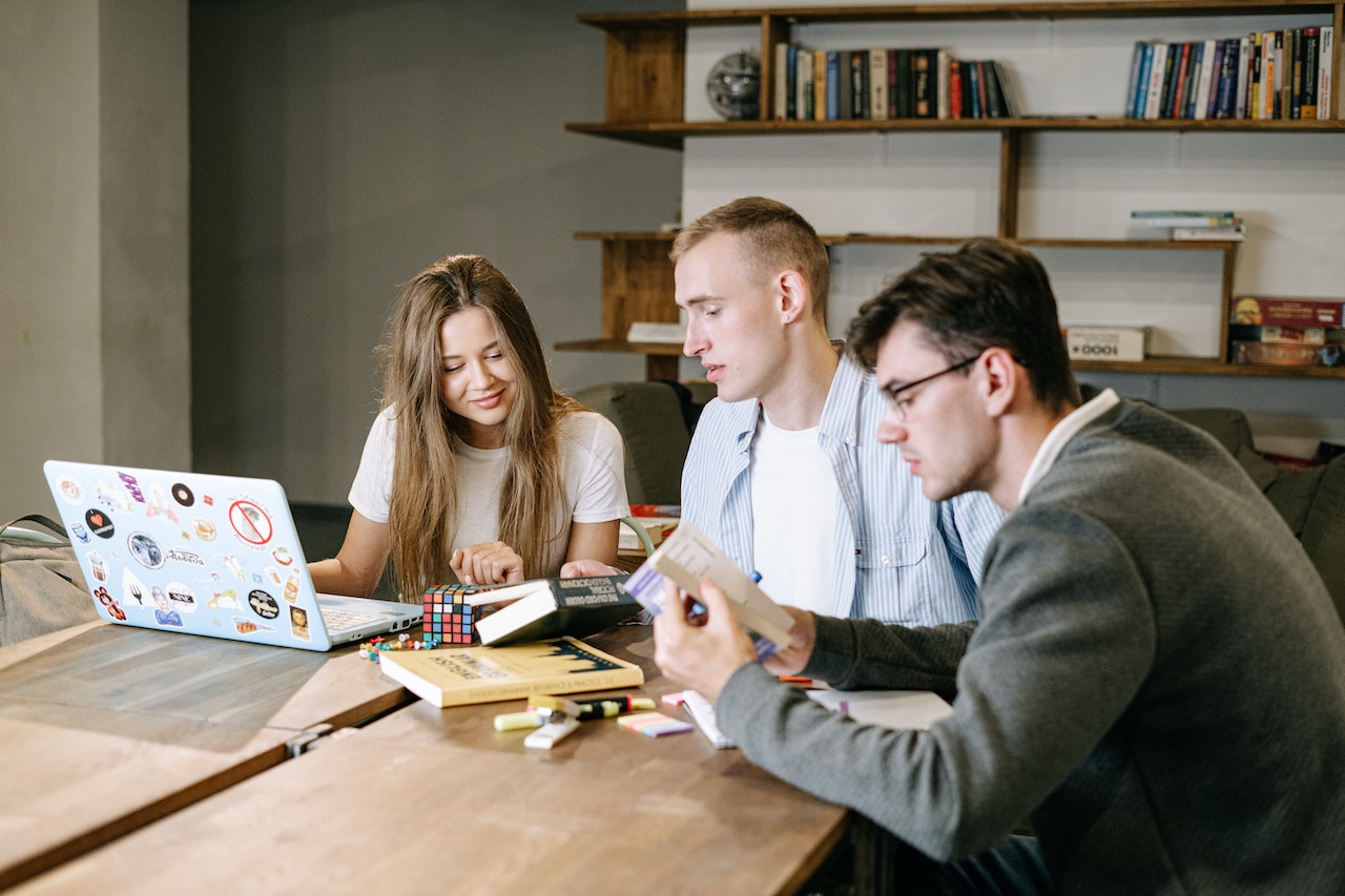 A photo of three colleagues working together in an informal office environment.