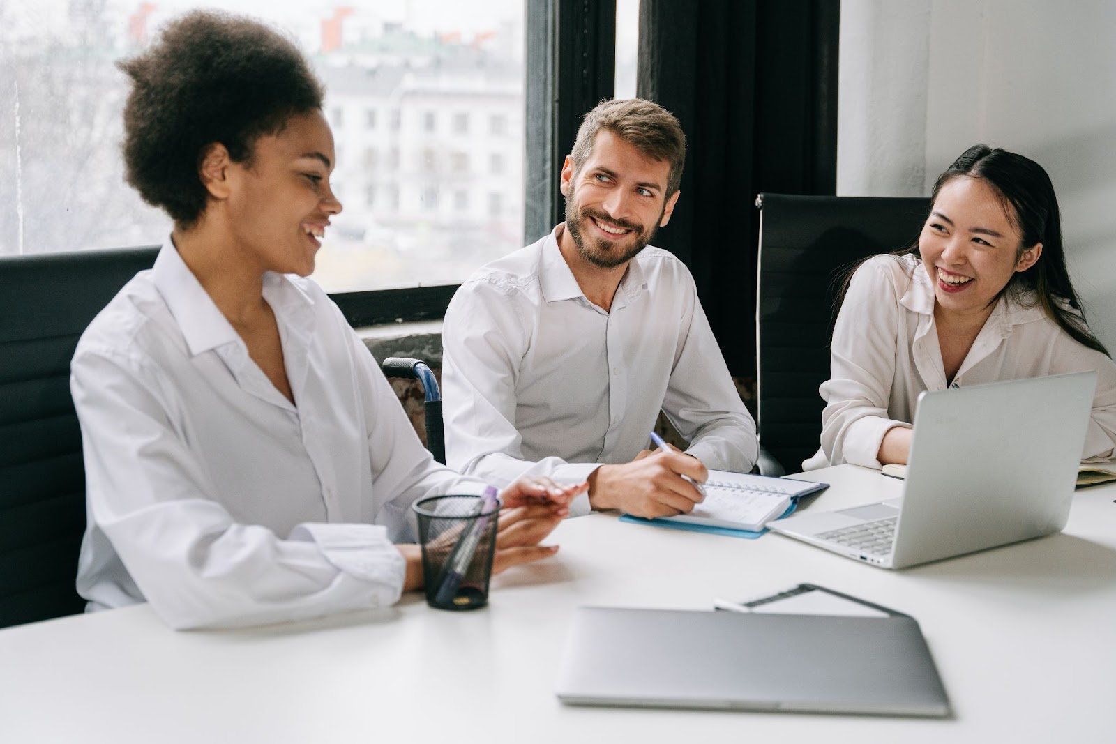 Photo of three employees in a meeting.