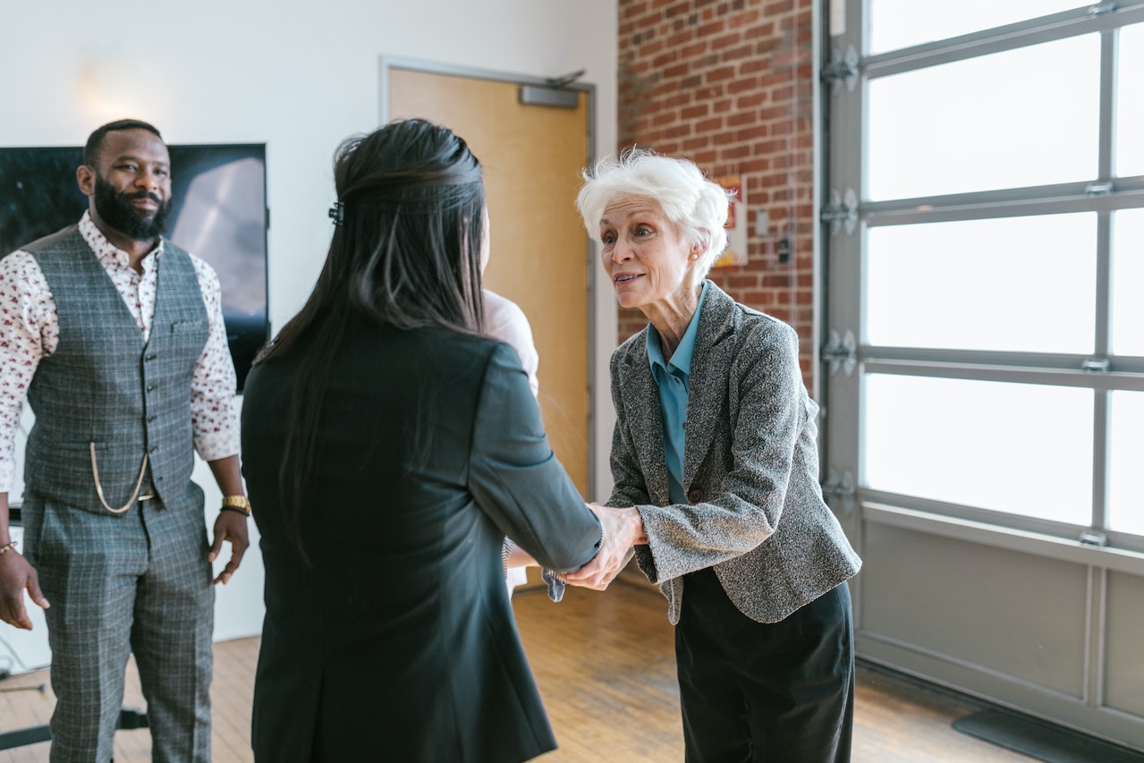 Photo of one employee shaking hands with another.