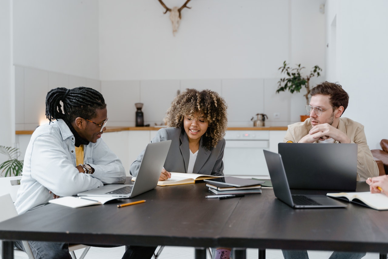 A photo of three professionals collaborating on a new retention agreement for their company.